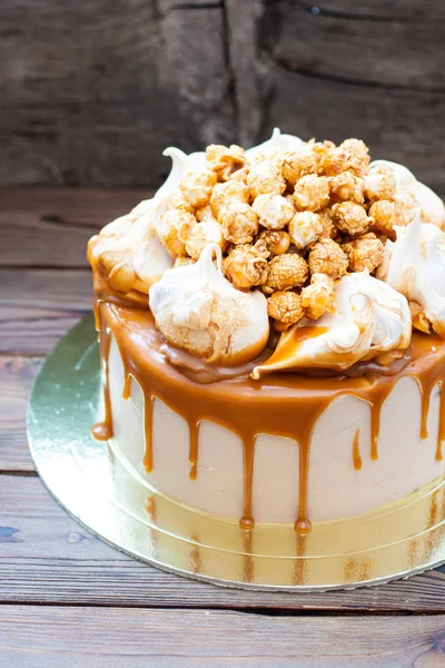 Chocolate cake with salted caramel sauce, meringue clouds and pop corn.