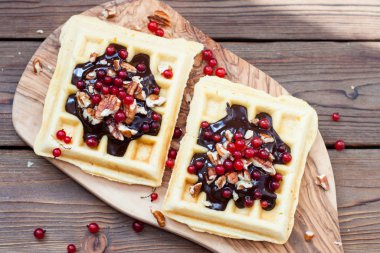 Erimiş çikolata, ceviz, kızılcık ve şeker tozlu ev yapımı waffle.