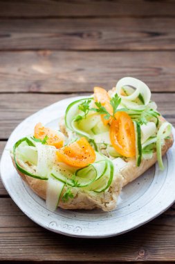 Krem peynir, taze kabak dilimleri, sarı domatesler, ahşap arka planda bitkiler ve biber.. 