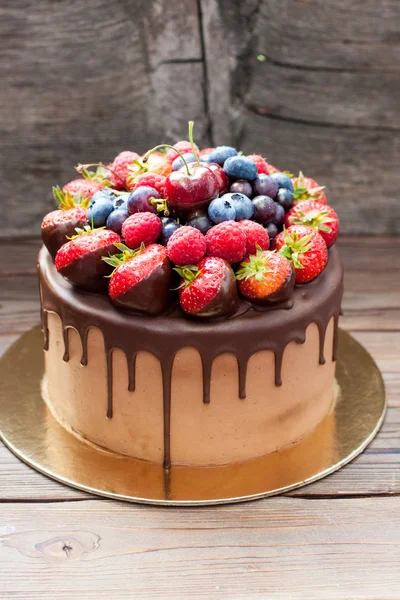 用融化的巧克力 新鲜草莓 覆盆子 蓝莓和葡萄制成的布朗尼蛋糕 背景为乡村棕色 — 图库照片