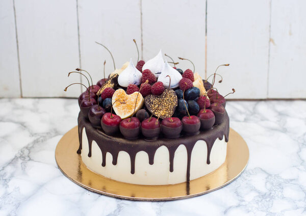 Чизкейк с темно-расплавленным шоколадом, свежей вишней, клубникой и черникой, шоколадными окропленными сердцами, безе
. 