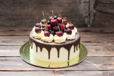 Vanilla cake with melted chocolate, swiss meringue frosting, fresh cherries, strawberries, raspberries, blueberries. 