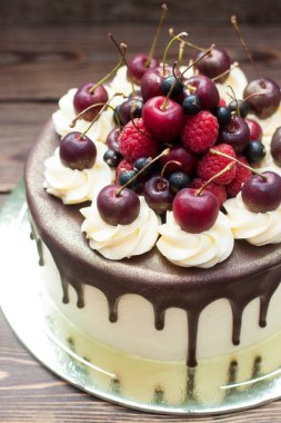 Vanilla cake with melted chocolate, swiss meringue frosting, fresh cherries, strawberries, raspberries, blueberries. 