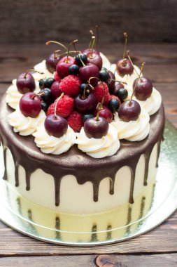 Vanilla cake with melted chocolate, swiss meringue frosting, fresh cherries, strawberries, raspberries, blueberries. 