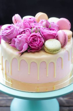 Pembe, fildişi ve turkuaz kek, erimiş beyaz çikolata, taze güller ve Fransız kurabiyeleri.  