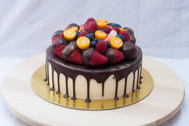 Koyu çikolatalı ve taze meyveli vanilyalı cheesecake, çilek, ahududu, yabanmersini ve kumkat.