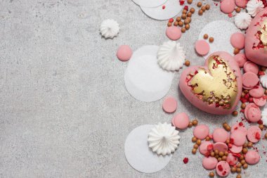 Çikolata damlaları, kremalar ve kurumuş meyvelerle sertleştirilmiş pembe kalpler.