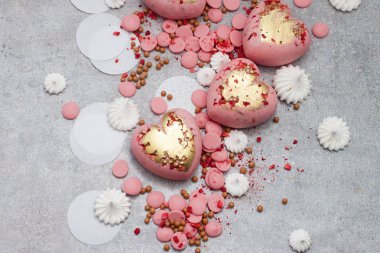 Çikolata damlaları, kremalar ve kurumuş meyvelerle sertleştirilmiş pembe kalpler.