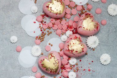 Çikolata damlaları, kremalar ve kurumuş meyvelerle sertleştirilmiş pembe kalpler.