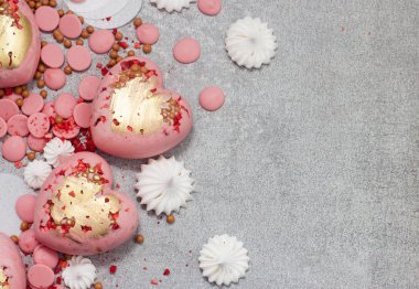 Çikolata damlaları, kremalar ve kurumuş meyvelerle sertleştirilmiş pembe kalpler.