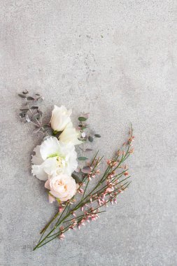 Gri taş arka planda zarif pastel renkli çiçekler.