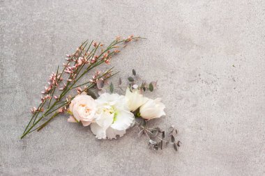 Gri taş arka planda zarif pastel renkli çiçekler.