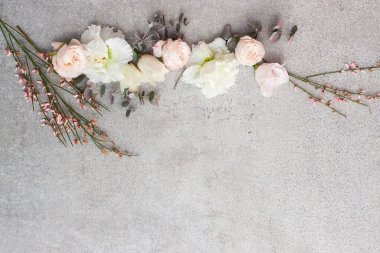 Gri taş arka planda zarif pastel renkli çiçekler.