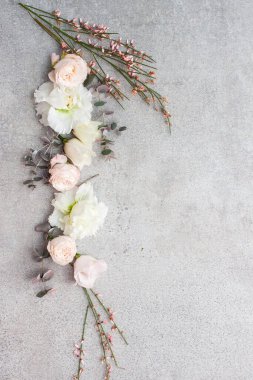 Gri taş arka planda zarif pastel renkli çiçekler.