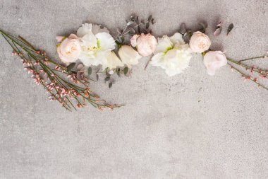 Gri taş arka planda zarif pastel renkli çiçekler.