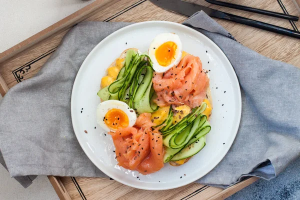 Smörgås med rostat bröd, rökt lax, färskost, skivad gurka och kokta ägg — Stockfoto