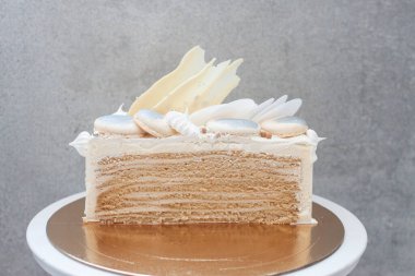 Çikolatayla süslenmiş, beyaz pasta üzerine katmanlı bal keki.