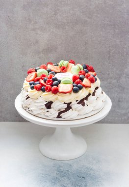 Big and elegant pavlova with meringues, whipped cream, melted chocolate and fresh berries clipart