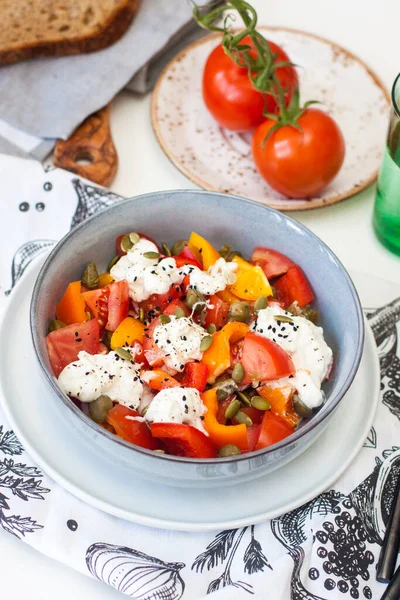 Verse gezonde salade met tomaten, gegrilde peper, kaas, pompoenpitten en zwarte sesam. — Stockfoto