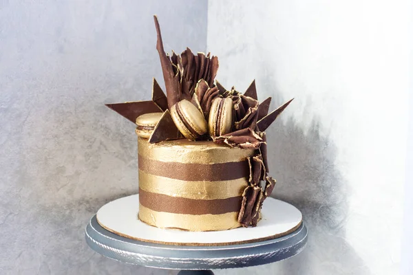 Chokladtårta Med Gyllene Ränder Mörk Chokladdekoration Och Makaroner Grå Bakgrund — Stockfoto