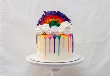 Eritilmiş çikolatalı LGBT gökkuşağı pastası ve beyaz pasta üzerinde karamel gökkuşağı. Düz beyaz arkaplan, alanı kopyala.