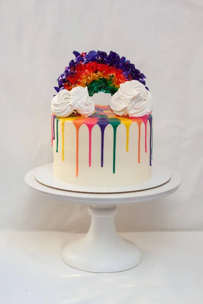 Eritilmiş çikolatalı LGBT gökkuşağı pastası ve beyaz pasta üzerinde karamel gökkuşağı. Düz beyaz arkaplan, alanı kopyala.