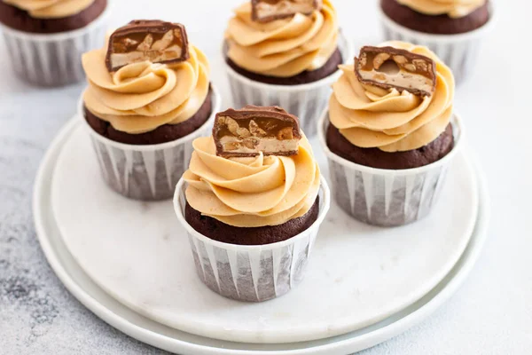 Zelfgemaakte chocolade deeg cupcakes met pindakaas glazuur en snickers beten. Selectieve focus — Stockfoto