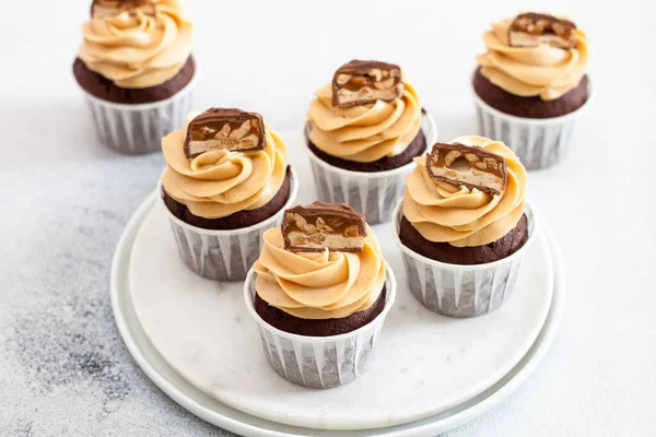 Zelfgemaakte chocolade deeg cupcakes met pindakaas glazuur en snickers beten. Selectieve focus — Stockfoto