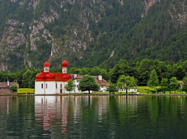 Красивый альпийский пейзаж - хрустальное озеро Кенигзе с небольшой церковью — стоковое фото