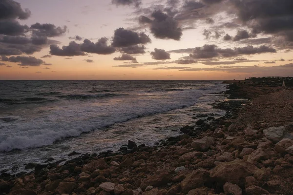 Sunset in Paphos, Cyprus. Sea and rocks, warm november day.