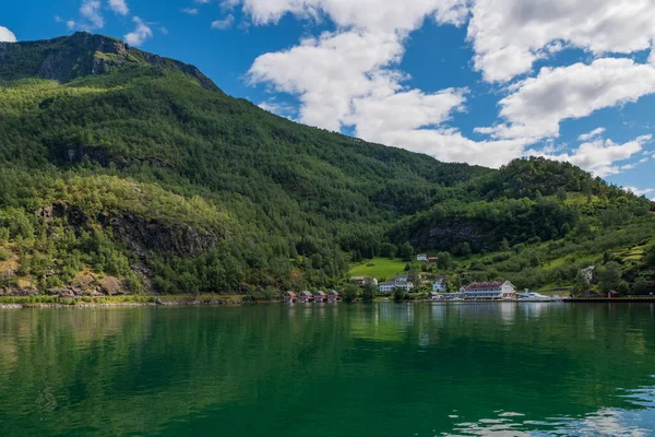 Een rij van rood huisje met kleine bootjes bij Flam, Noorwegen. juli 2019 — Stockfoto