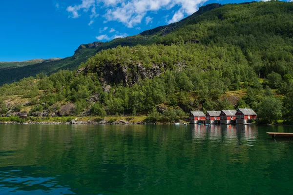 Een rij van rood huisje met kleine bootjes bij Flam, Noorwegen. juli 2019 — Stockfoto