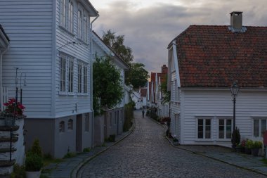 Gamle Stavanger 'da geleneksel ahşap evler. Gamle Stavanger, Norveç 'in Rogaland kentindeki Stavanger şehrinin tarihi bir bölgesidir. Renkli gökyüzü ile güzel bir yaz günbatımı. Temmuz 2019