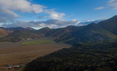 Eylül 2019 'da İzlanda' da. Büyük Vadi Parkı Landmannalaugar. Etrafı rhyolite dağları ve erimemiş karlarla çevrili. Vadide büyük bir kamp inşa edildi. Dünya turları konsepti. Hava aracı görüntüsü.
