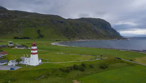 1852年にノルウェーのMore og Romsdal郡Alnesの漁村の港に漁船を導くために設立された古い有名な建物であるAlnes Lighthouse 。2019年7月の空中ドローンビュー — ストック写真