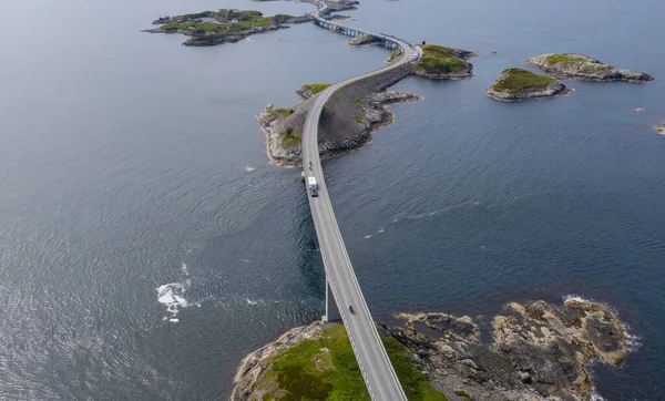 Atlantic road bridge Atlanterhavsvegen with view over the norwegian mountains. Road runs through an archipelago in Eide and Averoy in More og Romsdal, Norway. Aerial drone view, july 2019