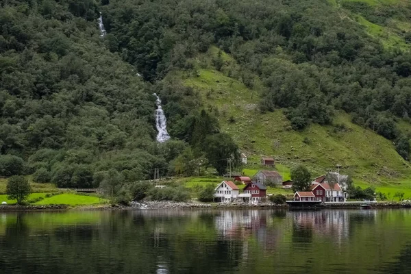 Santo Graal illustrato da Sognefjord o Sognefjorden creato da catena montuosa con cielo blu e riflessione in acque limpide e con un punto di banchina di legno in un fiume a Flom — Foto Stock