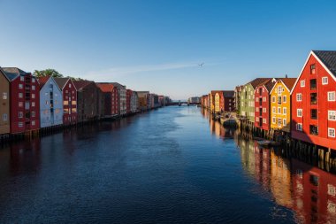 Norveç 'in Trondheim kentindeki Nidelva Nehri kıyısında tarihi kereste binaları bulunmaktadır. Temmuz 2019, gün batımı.