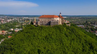 Ukrayna 'nın Transcarpathian bölgesindeki Mukachevo' da mavi gökyüzünün altında kırmızı çatıları olan Palanok Kalesi 'ne manzara. Hava aracı fotoğrafı..