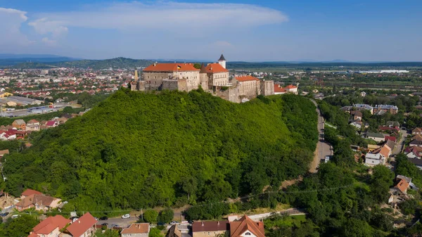 Ukrayna 'nın Transcarpathian bölgesindeki Mukachevo' da mavi gökyüzünün altında kırmızı çatıları olan Palanok Kalesi 'ne manzara. Hava aracı fotoğrafı..