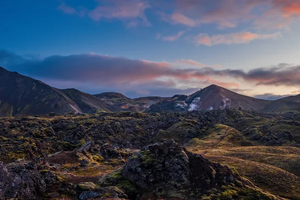 Исландия в сентябре 2019 года. Парк Great Valley Landsalaugar, окруженный горами риолита и нерастаявшим снегом. В долине построен большой лагерь. Вечер в сентябре 2019 г. — стоковое фото