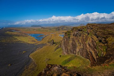 Reynisfjara Black Sand Beach, İzlanda 'nın güney kıyısında güneşli bir günde bir uçurumdan görülen Vik i Myrdal köyünün yakınlarında bulundu. Eylül 2019