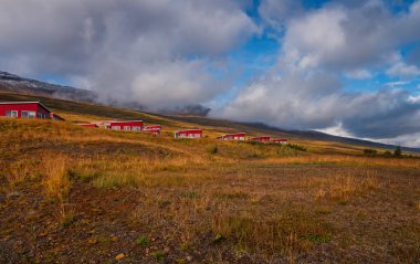 Akureyri İzlanda - Eylül 2019 - Akureyri 'de güzel bir yaz günü, binalar, karlı dağlar ve mavi gökyüzü arka planda.