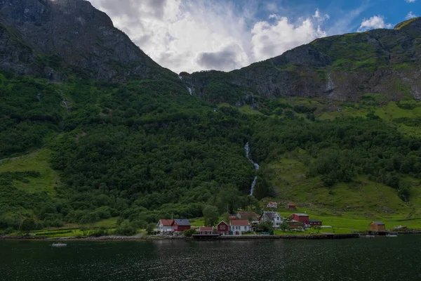 Hegyek, falu és norvég főúr Neroyfjord Sognefjord. Kék ég felhőkkel. 2019. július — Stock Fotó