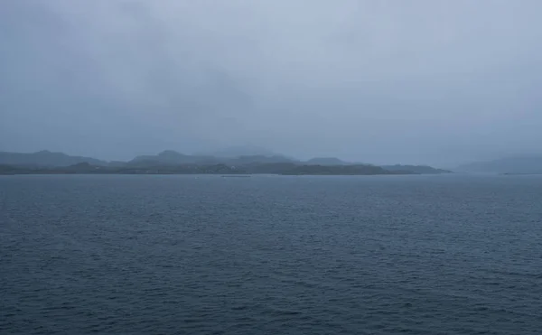 Um dos ferries de carro entre Mortavika e Arsvagen navegando em mar agreste com algumas ondas grandes e paisagem serrana no fundo, Noruega — Fotografia de Stock