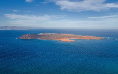 İspanya 'nın Kanarya Adaları, Fuerteventura sahilinin sadece 2 kilometre açığındaki ıssız bir ada olan Isla de Lobos' un çarpıcı yüksek açılı panoramik hava aracı görüntüsü. Ekim 2019