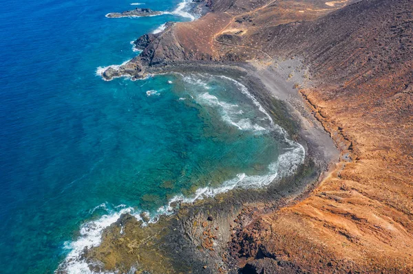 Kanarieöarna, Spanien, oktober 2019: Flygfoto över den svarta stranden från toppen av berget Caldera, den antika vulkanen Lobos Island Islote de Lobos, en liten ö 2 km norr om Fuerteventura — Stockfoto