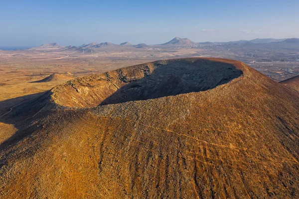Beautiful panoramic birds eye view on Calderon Hondo, Fuerteventura island. Aerial shooting vulcano around mountains with ocean coastline at sunny day. Travell, Mountains,islands, nature, concept.