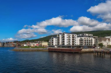 Molde, Norveç - Temmuz 2019. İskandinav dağları ve mavi gökyüzünün arka planında modern mimari. Molde, Norveç 'te güneşli bir gün.
