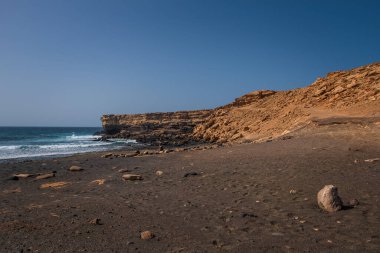 La Pared volkanik plajı veya Playa de La Pared Fuerteventura güney batı kıyısı, Kanarya Adaları, İspanya, aşınmış manzara ve siyah kumla. Ekim 2019